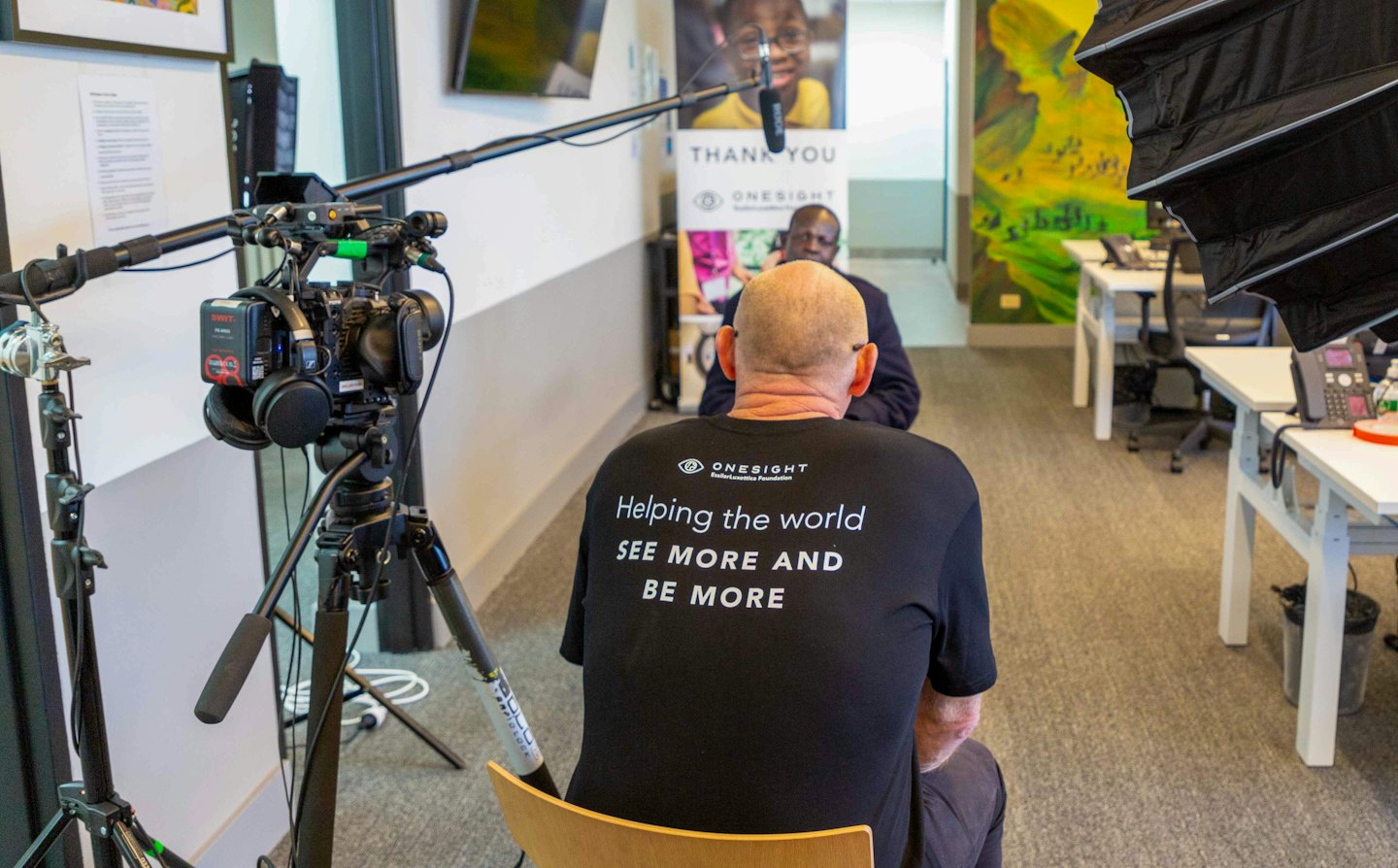 A producer sits at a desk during a professional video interview.