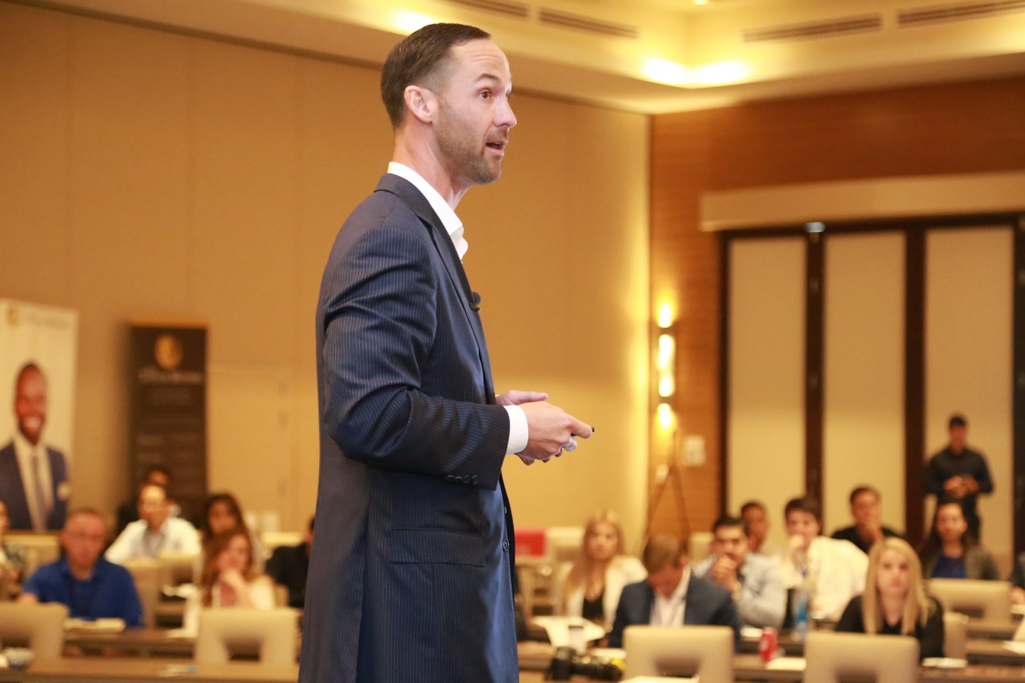 Speaker in a suit presents at a business conference.